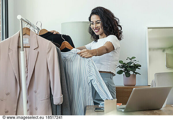 Happy fashion designer checking new collection at studio