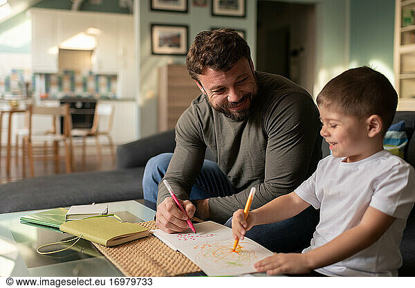 Happy father and son drawing pictures together