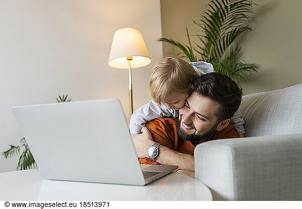 Happy father and son enjoying in living room at home