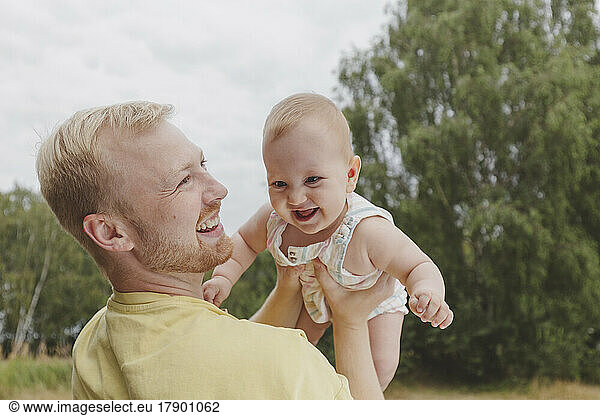 Happy father playing with daughter in park