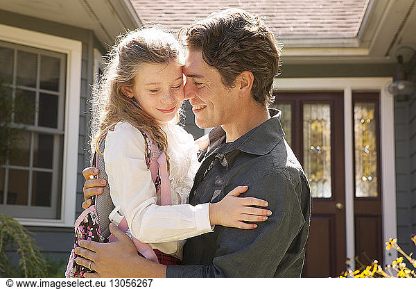 Happy father with daughter outside house