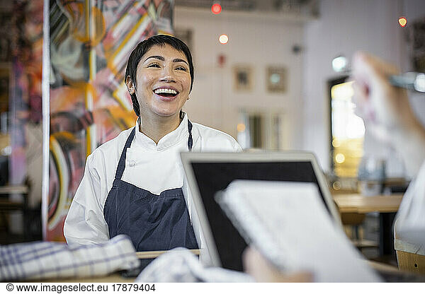 Happy female business owner with short hair sitting in restaurant