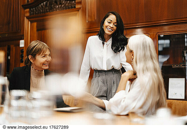 Happy female financial advisors discussing at office