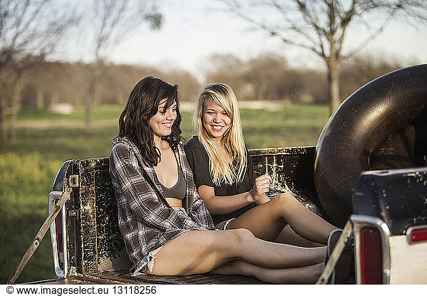Happy female friends relaxing in vehicle trunk