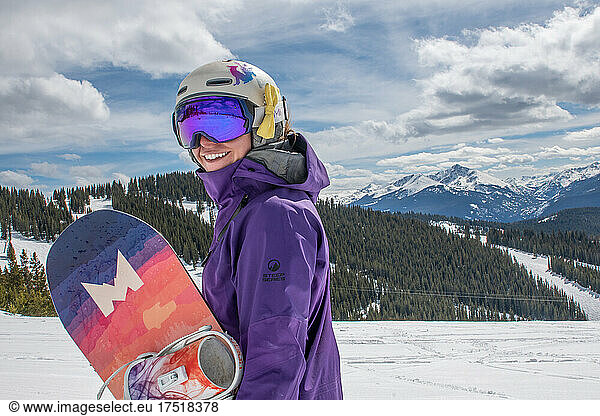 Happy Female Snowboarder on a mountain top in Colorado