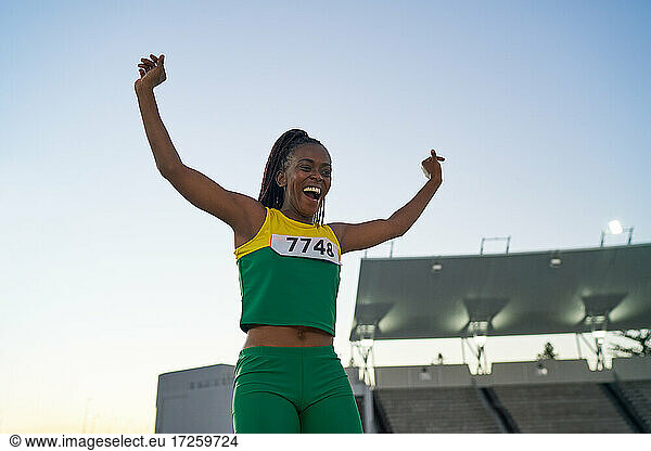 Happy female track and field athlete celebrating at competition