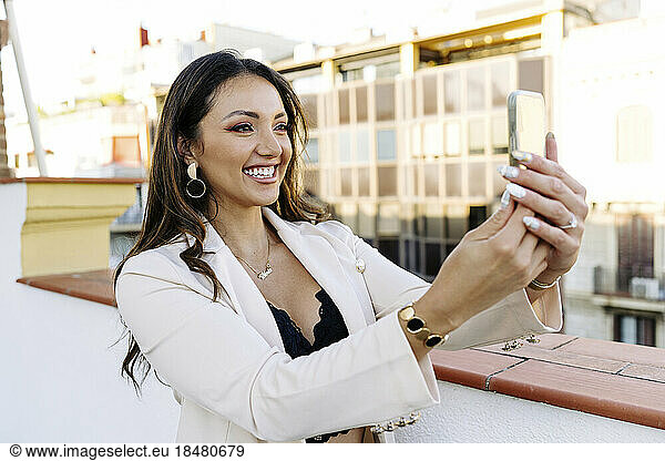 Happy freelancer taking selfie through mobile phone