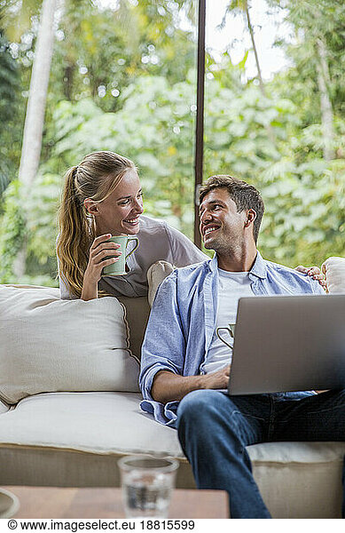 Happy freelancer with woman holding coffee cup at home