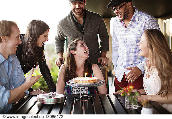 Happy friends at dining table during birthday party on porch