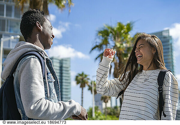 Happy friends laughing together at park