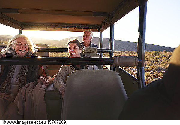 Happy friends riding in safari off-road vehicle