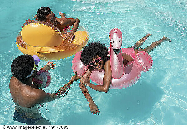 Happy friends together enjoying in swimming pool