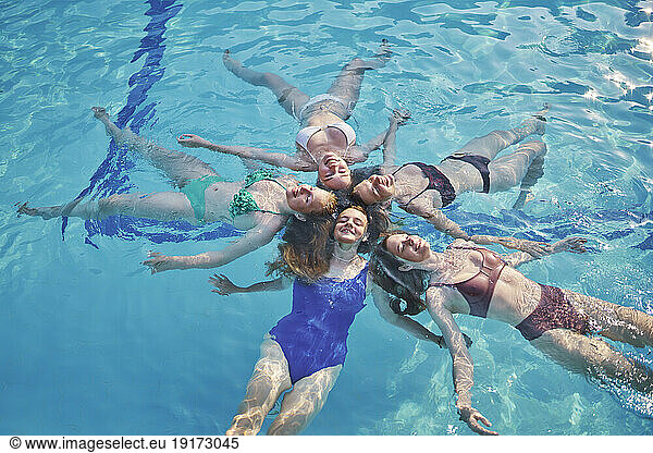 Happy friends together swimming and enjoying in pool