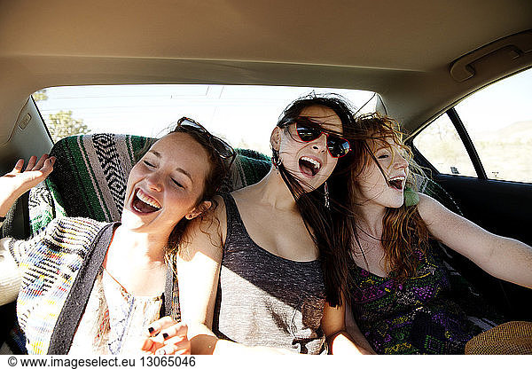 Happy friends traveling in car