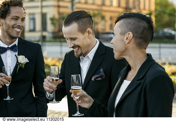 Happy friends with champagne during wedding ceremony