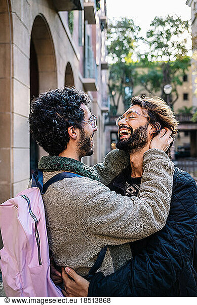 Happy gay men embracing and laughing together