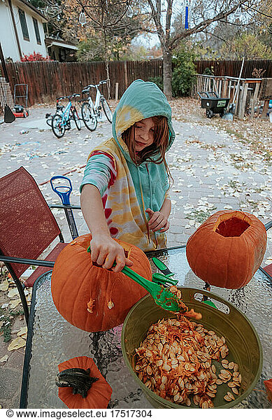 Happy girl carving pumpkins for halloween