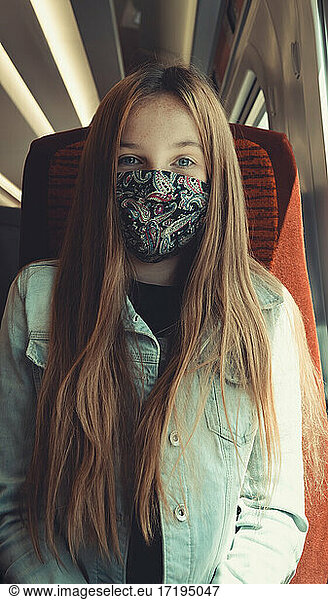 happy girl on transport wearing a mask looking into camera