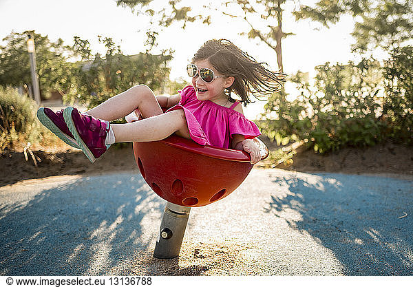 Happy girl playing on spring ride at playground