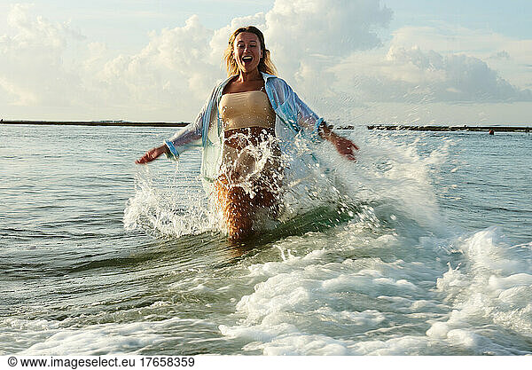 happy girl running on waves in bali island