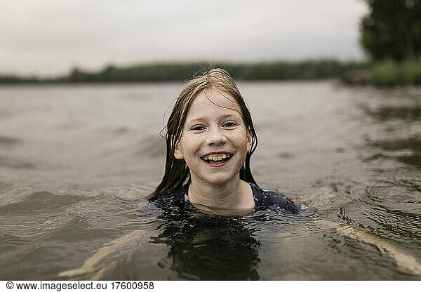 Happy girl swimming in lake