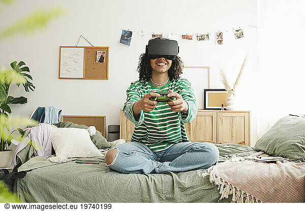 Happy girl wearing virtual reality simulators playing video game with controller at home