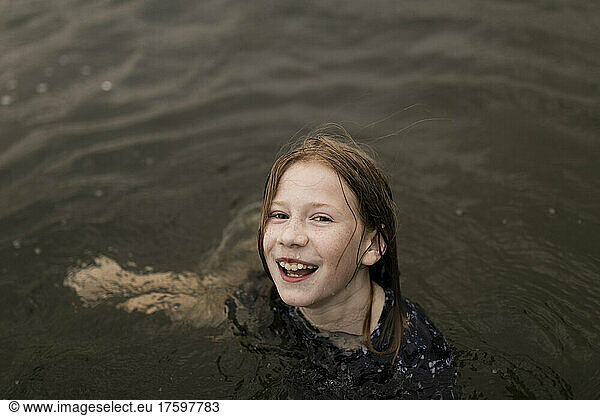 Happy girl with brown hair playing in water