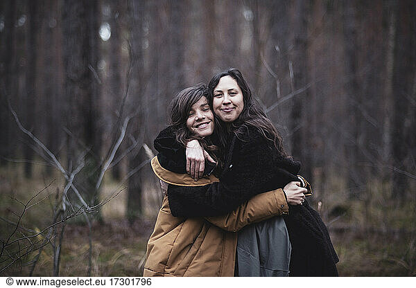 Happy girlfriends hug and smile outdoors in the forrest in germany
