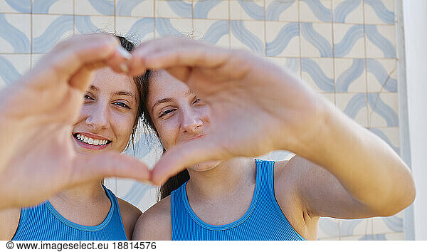 Happy girls gesturing heart shape