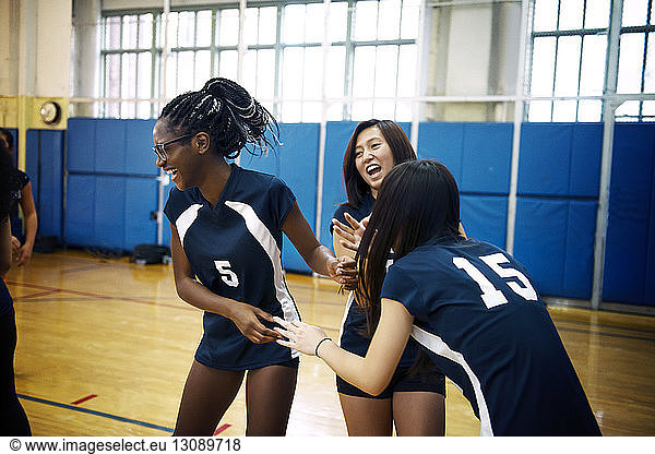 Happy girls playing in volleyball court