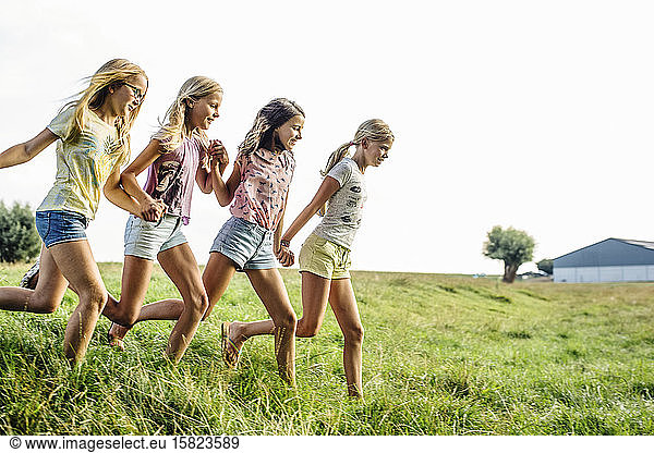 Happy girls running on a field in the countryside