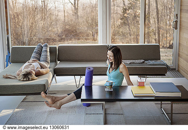 Happy homosexual women spending leisure time in living room