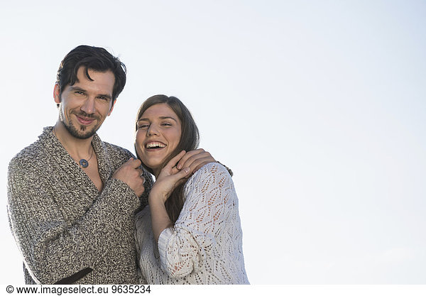 Happy laughing couple embracing sunset