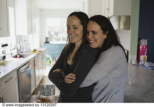 Happy lesbian couple embracing at home