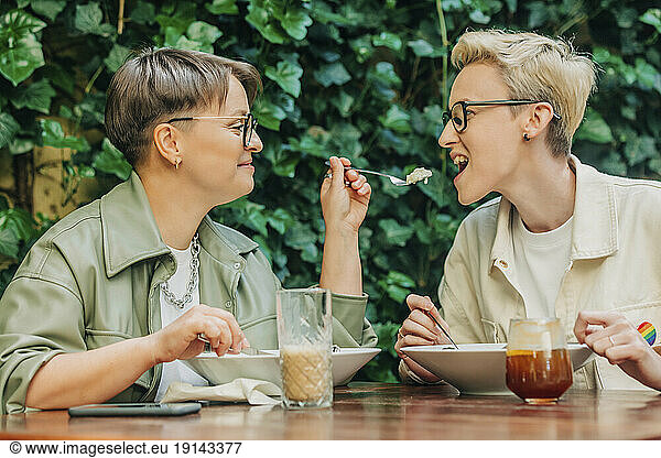 Happy lesbian couple having food together at cafe