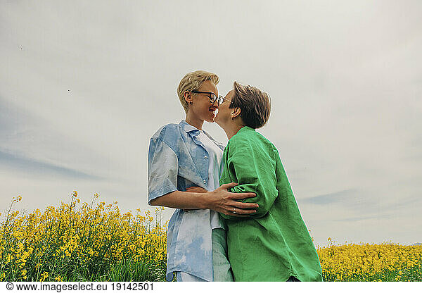 Happy lesbians embracing each other at field