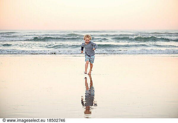 Happy little boy running on beach
