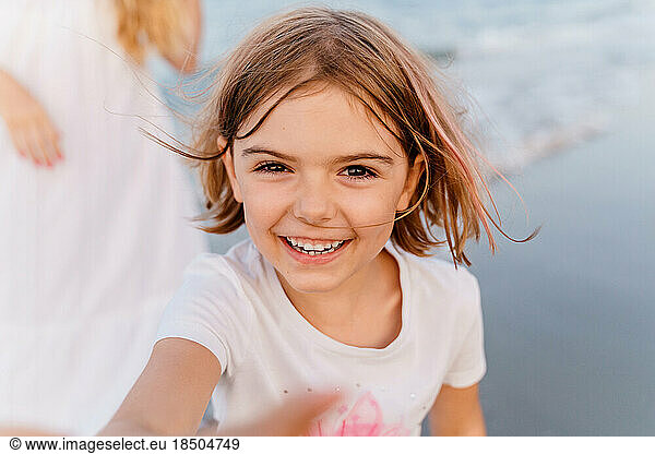 Happy little girl with quads laughs merrily on the beach