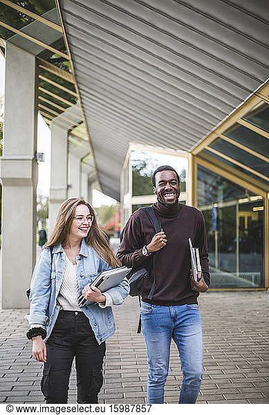 Happy male and female students at university