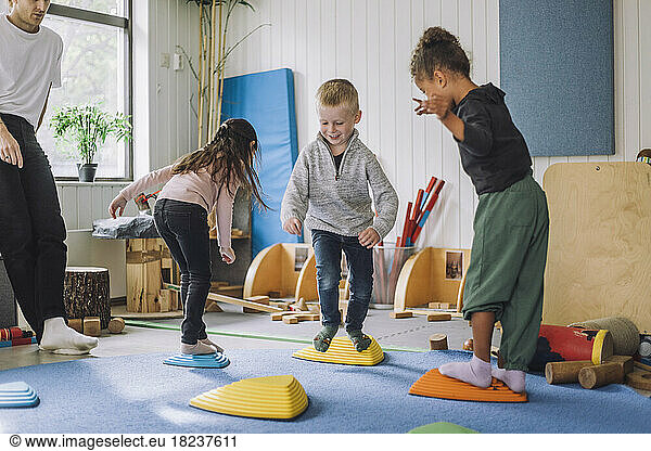 Happy male and female students playing in kindergarten
