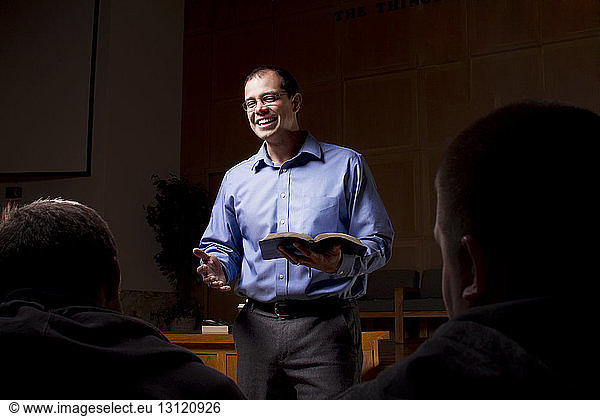 Happy male professor teaching in college classroom