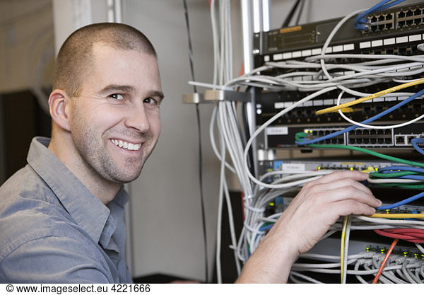Happy man fixing network cables