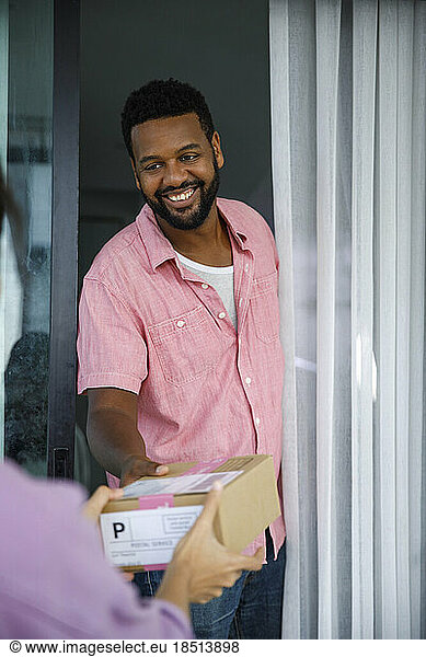 Happy man receiving parcel at doorway