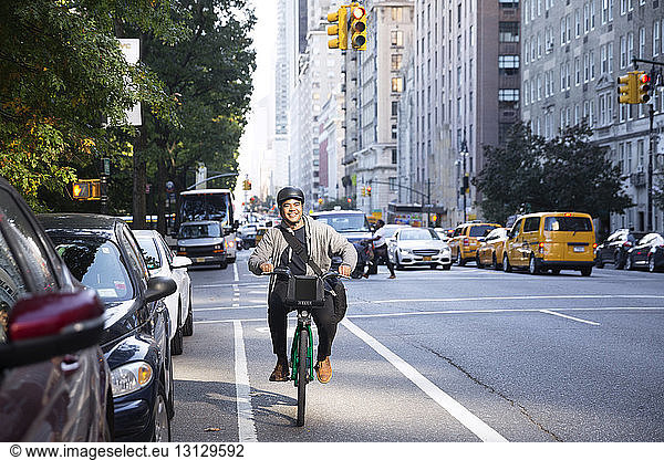 Happy man riding bicycle on city street