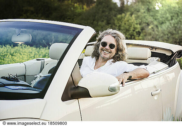 Happy man sitting in a car Beetle Cabrio  Bavaria  Germany