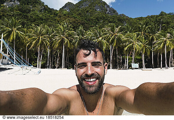 Happy man taking selfie at beach