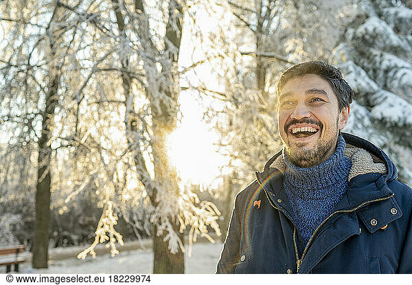 Happy man wearing warm clothing in winter park