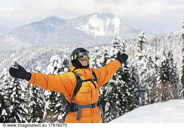 Happy man with arms outstretched enjoying in winter