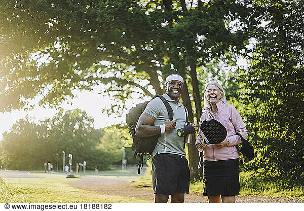 Happy man with backpack standing with senior woman