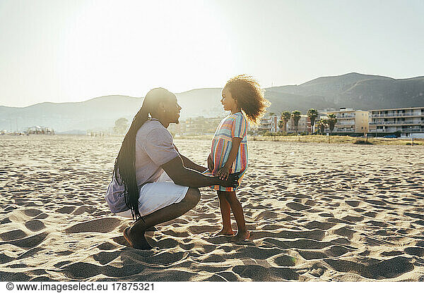 Happy man with daughter at beach on sunny day